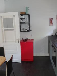 eine Küche mit einem roten Schrank und einer roten Tür in der Unterkunft schön eingerichtete Ferienwohnung in zentraler Ortslage in Ahrensbök + 6 Fotos
