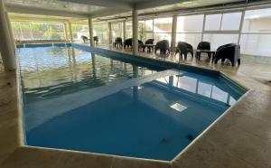 a large swimming pool with chairs in a building at Apart Hotel Bs.As.Mar in San Clemente del Tuyú
