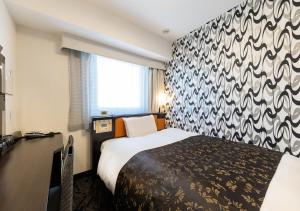 um quarto de hotel com uma cama e uma parede estampada em APA Hotel Chiba Ekimae em Chiba