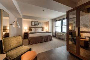 a hotel room with a bed and a chair at Claridge House Chicago, Tapestry Collection by Hilton in Chicago +63 photos