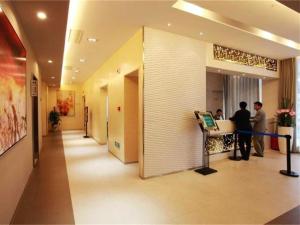 two people standing in a hallway in a building at Jinjiang Inn Jiaozuo Jianshe Road in Jiaozuo