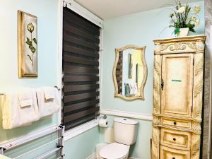 a bathroom with a toilet and a wooden cabinet at Barker House 1# Suite-heart of oldtown in Niagara on the Lake +12 photos