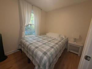 Un dormitorio pequeño con una cama y una ventana. en Two fully independent unit - a modern house and a private apartment, each with its own entrance, located just 15 min from Sea-Tac Airport and 5 min from Des Moines Marina, en Des Moines