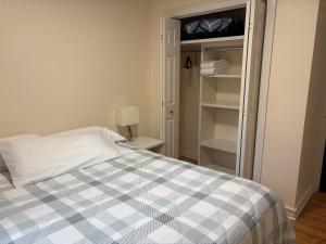 1 dormitorio con cama y armario abierto en Two fully independent unit - a modern house and a private apartment, each with its own entrance, located just 15 min from Sea-Tac Airport and 5 min from Des Moines Marina, en Des Moines