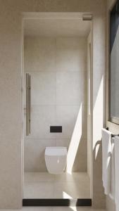 a bathroom with a white toilet in a shower at New Luxury Ribamar Villas in Uluwatu +3 photos