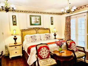 a bedroom with a bed and a table and chairs at Barker House 1# Suite-heart of oldtown in Niagara on the Lake