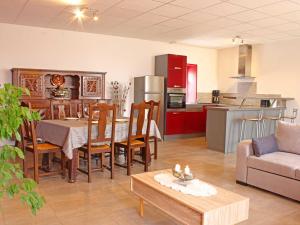 a kitchen and living room with a table and a couch at Maison de ferme rénovée avec SPA et salle de jeux - FR-1-489-28 in Cressanges