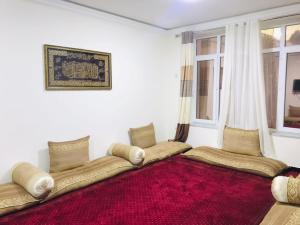 a living room with a couch and a red rug at Kabul Blue Star Guest House in Deh Sabz
