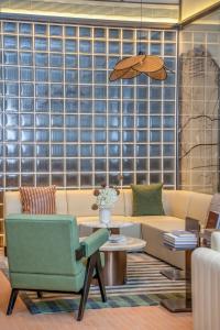 a living room with a couch and a chair at Dahua Group Xinn Hotel (Haikou West Coast Convention & Exhibition Center Branch) in Zhenhai