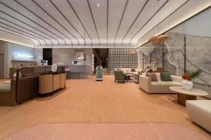 a large lobby with couches and tables in a building at Dahua Group Xinn Hotel (Haikou West Coast Convention & Exhibition Center Branch) in Zhenhai
