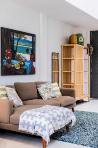 een woonkamer met een bank en een schilderij aan de muur bij TownHouse6 2BR MonkeyHill in Ban Sam Kong