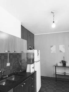 a kitchen with a white refrigerator and a sink at Sol de Mayo in Tinogasta
