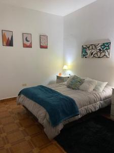 a bedroom with a bed with a blue blanket on it at Sol de Mayo in Tinogasta