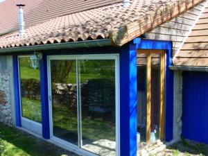 a house with blue windows and a brown roof at Maison éco-gîte avec SPA, terrasse, et chauffage solaire près de Vichy - FR-1-489-290 in Bransat +4 photos
