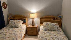 a small bedroom with two beds and a lamp at Northeast Bay Escape 