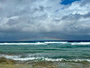 a beach with waves in the ocean on a cloudy day at Northeast Bay Escape 