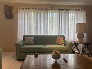 a living room with a green couch and a coffee table at Northeast Bay Escape 