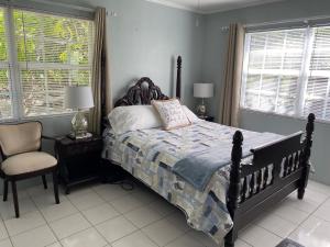 a bedroom with a bed and a chair and windows at Northeast Bay Escape 