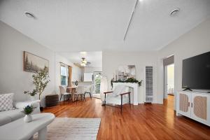 ein Wohnzimmer mit weißen Möbeln und einem Flachbild-TV in der Unterkunft Cozy Comfort Stylish 2BR 1BA near LAX, LMU, SoFi Stadium & Beaches in Los Angeles