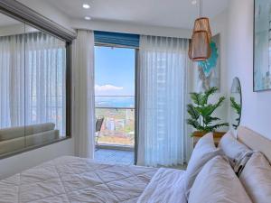 Un dormitorio con una cama y una ventana grande. en The Sóng Apartment Vũng Tàu, en Vung Tau 99 fotos más