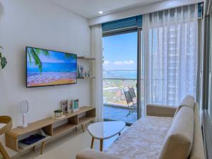 Una sala de estar con un sofá y una ventana grande. en The Sóng Apartment Vũng Tàu, en Vung Tau