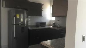 una cucina con mobili neri e un frigorifero in acciaio inossidabile di Casa Bella Mansion a Nariño