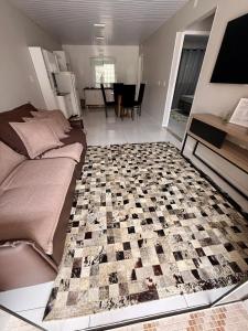 ein Schlafzimmer mit einem Bett und einem Schachbrettboden in der Unterkunft Casa charmosa praia Itapema in Itapema