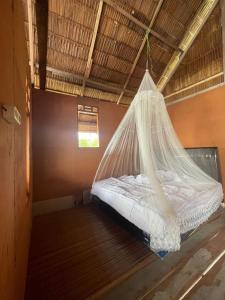 a bed in a room with a mosquito net at THE Drift Wood House in Besir