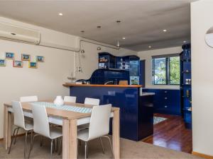 a kitchen and dining room with a wooden table and chairs at La Belle Maison - Ruakaka Holiday Apartment in Ruakaka