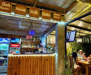 ein Restaurant mit Bar, in dem Leute an Tischen sitzen. in der Unterkunft Marion Roos Hotel in Puerto Galera