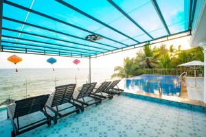 a group of chairs sitting next to a swimming pool at Palado Hotel Mui Ne in Ấp Thiện Phước