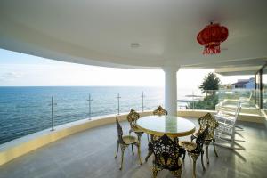 a table and chairs on a balcony with the ocean at Palado Hotel Mui Ne in Ấp Thiện Phước +4 photos