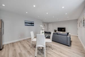 a living room with a couch and a table and chairs at Spacious 1BR Suite Near Capilano Bridge & Trails in North Vancouver
