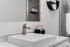 een witte wastafel in een badkamer met een spiegel bij Modern 2Bed Suite Near Capilano Bridge & Trails in North Vancouver +20 foto's