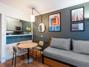 a living room with a couch and a table at Aparthotel Adagio La Défense Le Parc in Courbevoie
