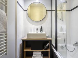 a bathroom with a sink and a shower at Aparthotel Adagio La Défense Kléber in Courbevoie
