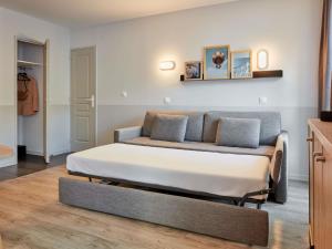 a bed in a room with a couch at Aparthotel Adagio Val d'Europe près de Disneyland Paris in Serris +55 photos