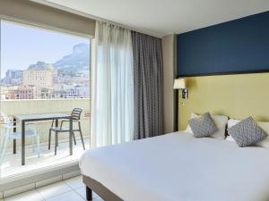 een hotelkamer met een bed en een balkon bij Aparthotel Adagio Monaco Monte Cristo in Beausoleil