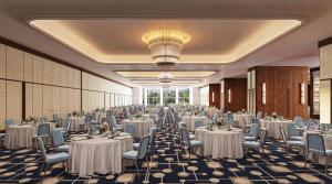 a banquet hall with white tables and chairs and a chandelier at Conrad Athens The Ilisian in Athens