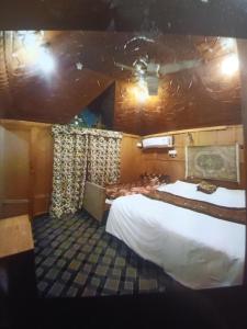 une chambre avec un grand lit dans une pièce dans l'établissement T luxury Heritage houseboat, à Srinagar
