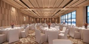 a banquet hall with white tables and chairs at Hilton Altay Hemu in K'u-mu