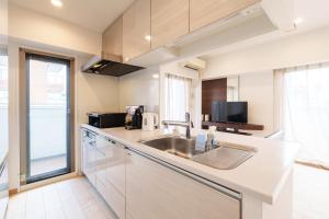 a kitchen with a sink and a microwave at 青葉邸 AOZORA 1002 Near Dotonbori 3LDK 2 Bath 2 WC Premium Tower Residence in Osaka