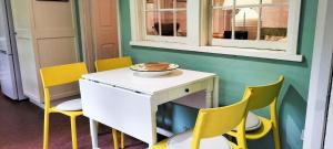 eine Küche mit gelben Stühlen und einem Tisch mit einer Schüssel darauf in der Unterkunft Redruth - 2 bedroom cottage situated in wandiligong in Wandiligong + 12 Fotos