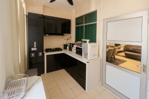 Una pequeña cocina con encimera y microondas. en Arlyn's Homestay, en Sandakan