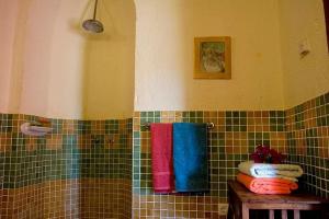 a bathroom with colorful towels on a tiled wall at Gîte El Conejo in Alájar