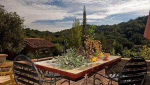 a table with fruits and vegetables on a patio at Gîte El Conejo in Alájar +5 photos