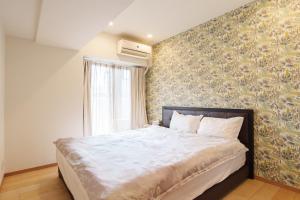 a bedroom with a large bed with a floral wallpaper at 青葉邸 AOZORA 1002 Near Dotonbori 3LDK 2 Bath 2 WC Premium Tower Residence in Osaka +70 photos