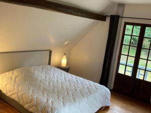 ein Schlafzimmer mit einem weißen Bett und einem Fenster in der Unterkunft Retraite Paisible au Cœur de la Forêt de Rambouillet avec Étang Privé et Charme Authentique - FR-1-527-8 in Clairefontaine