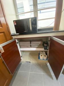 a kitchen with a microwave and a desk with towels at Jo’s Place Cameron Highlands EA922 in Brinchang