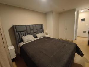 a bedroom with a large bed with a large headboard at Apartment overlooking the water park in Lima